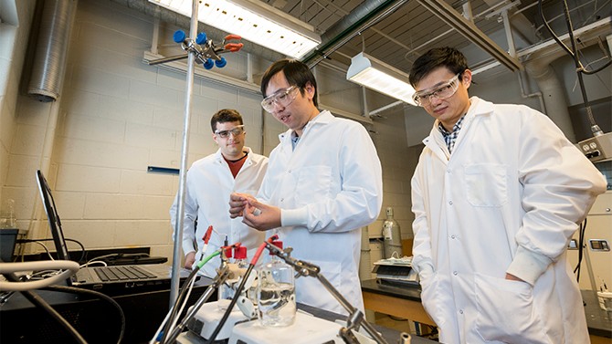 three men in white lab coats