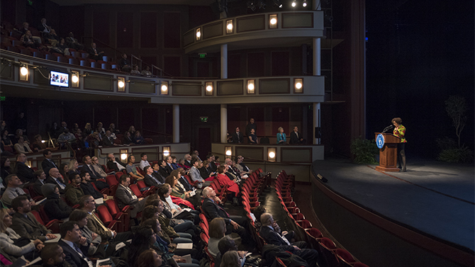 Gabrielle Foreman in front of auditorium of people for Inauguration Symposium