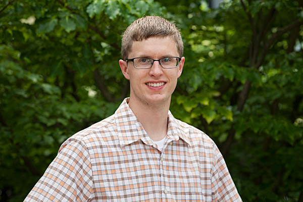 man in front of green trees